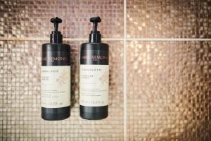 two shampoo bottles on a wall in a bathroom at B&B X2Brussels in Brussels