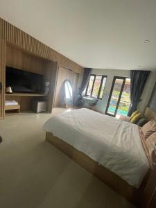 a bedroom with a large bed and a television at Tự Do Homestay Huế in Hue