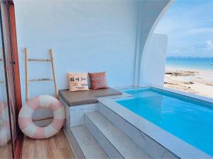 a house with a swimming pool and a chair and a ladder at All at Sea Kohlarn in Ko Larn