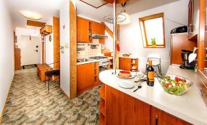 a kitchen with wooden cabinets and a counter top at Apartament Milena in Polanica-Zdrój
