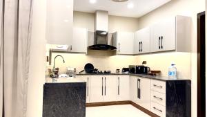 a kitchen with white cabinets and a sink at Executive 2BHK in Zeta Mall in Islamabad