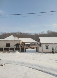 a house with snow on the ground in a yard at Harmony Vendégház Egerszalók in Egerszalók