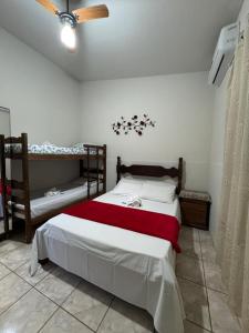 un dormitorio con una cama y dos literas en Pousada Serra da Canastra 3, en Vargem Bonita