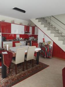eine Küche mit roten Schränken sowie einem Tisch und Stühlen in der Unterkunft Retiro D'Ouro - Casa inteira in Sendim