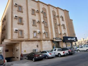 a large building with cars parked in front of it at غولدن إليت للشقق المخدومة الأجاويد Golden Elite Serviced apartment alajawed in Jeddah