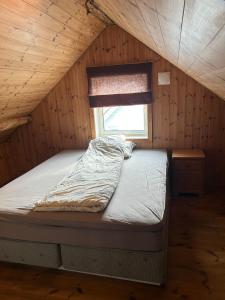 a bed in a wooden room with a window at Cozy top apartment in Egersund city with 3 bedrooms in Egersund