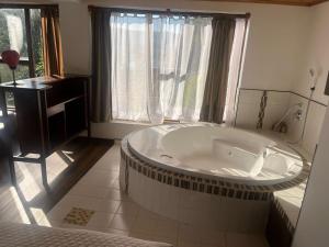 a large bath tub in a bathroom with a window at Refugio Génesis habitaciones Lago de Tota in Tota +60 photos