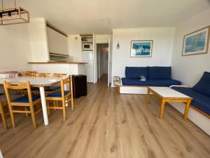 Appartement climatisé 6 personnes في سانت رافائيل: غرفة معيشة مع طاولة وأريكة زرقاء