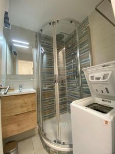 Appartement climatisé 6 personnes في سانت رافائيل: دش في حمام مع حوض وكاونتر