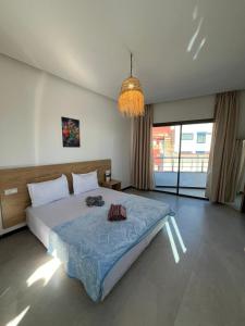 a bedroom with a large bed and a chandelier at Atlantic view Tamraght 2 in Tamraght Ou Fella