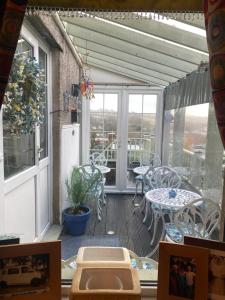 a patio with a table and chairs on a balcony at Butterfly House in Blackwood