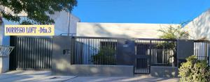 a building with a gate with a sign on it at Dorrego Loft in Barraquero