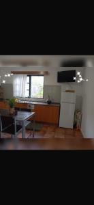 a kitchen with a table and a refrigerator in it at House Silvia & Nuno´s in Machico