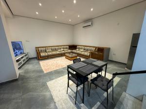 una sala de estar con una mesa y un sofá en Alnuaman farm, en Barka