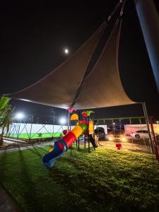 Un parque infantil en una tienda de campaña por la noche en Alnuaman farm, en Barka 7 fotos más