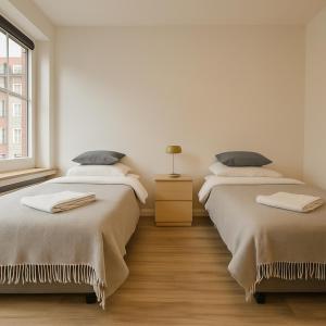 two beds sitting next to each other in a room at Old Town Apartments in Düsseldorf