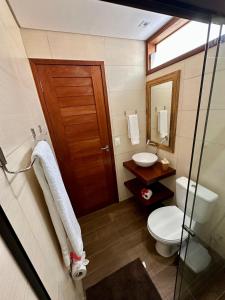 a bathroom with a toilet and a sink and a mirror at Arraia Suítes Pousada in Pipa +120 photos
