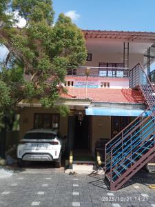 un coche está estacionado frente a una casa en AB Island Homestay, en Munroe Island