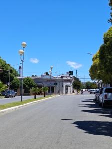 坦迪尔Hotel Francia的一条空荡荡的街道,路边有汽车停放