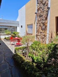 a courtyard with a table and chairs and a building at Hotel Francia in Tandil