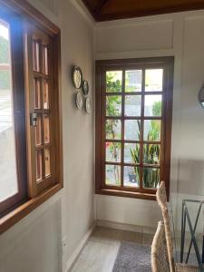 comedor con 2 ventanas y mesa en Refúgios SUNSET Serra Fluminense, en Areal