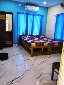 Un dormitorio con una cama con paredes azules y cortinas azules. en AB Island Homestay, en Munroe Island
