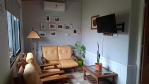 a living room with a chair and a tv at OMA- Casa Temporaria in Capilla del Monte