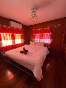 a bedroom with a bed with a teddy bear on it at Family house in Ban Laem Sai
