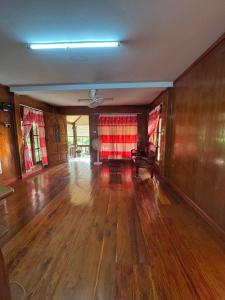 an empty living room with a couch and wooden floors at Family house in Ban Laem Sai
