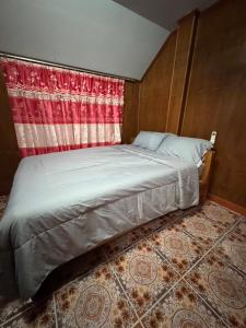 a bed in a room with a red curtain at Family house in Ban Laem Sai +3 photos