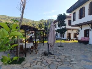 a patio with an umbrella and a table and chairs at İkiz Konaklar in Selçuk