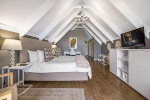 内尔斯普雷特洛瑞的呼唤旅馆的卧室里有一张白色的大床和一台电视