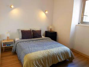 Foix centre - T2 vue sur le Château في فوا: غرفة نوم بها سرير مع لحاف أزرق وأبيض