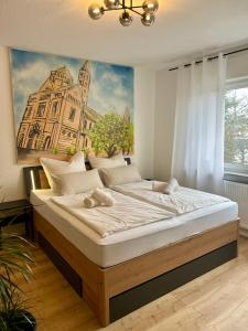 Un dormitorio con una cama grande con un cuadro en la pared. en Pfalz-Studio in Speyer - stilvoll, modern & zentral, en Speyer
