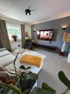a living room with a flat screen tv on a wall at Gemütliche Doppelhaushälfte mit Garten und Sauna in Frechen