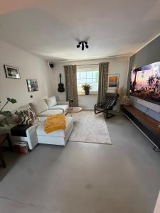 a living room with a white couch and a flat screen tv at Gemütliche Doppelhaushälfte mit Garten und Sauna in Frechen