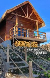 a log cabin with a sign in front of it at Casablanca Bira Resort in Tabutule