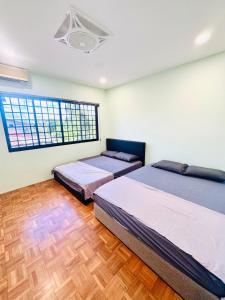 a bedroom with two beds and a window at HMHome-Seven in Sibu