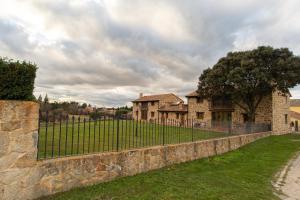 a stone fence in front of a house at Complejo Rural La Venta Vieja by CABANA Rentals in Ortigosa del Monte