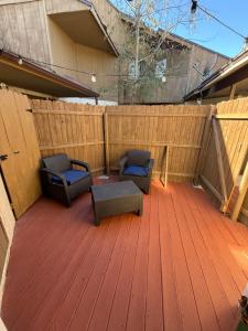 two chairs on a wooden deck with a fence at Cozy, private studio in Jacksonville