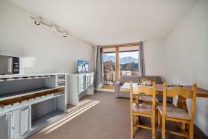 a kitchen and dining room with a table and chairs at Mountain View with Ski-In and Out Loft - Résidence Roche Blanche in Val Thorens