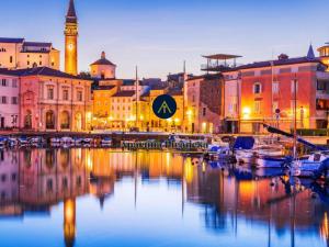 a city with boats in a harbor with a clock tower at Apartma Piranesa III in Piran