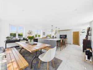 Luxurious 4 Bed Property: Chiltern Hills - Pass the Keys في Ibstone: مطبخ وغرفة معيشة مع طاولة وكراسي خشبية