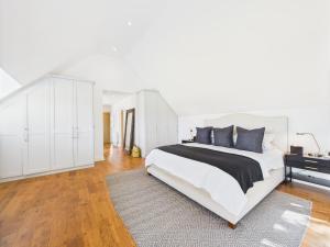 Luxurious 4 Bed Property: Chiltern Hills - Pass the Keys في Ibstone: غرفة نوم بيضاء مع سرير كبير وخزانة