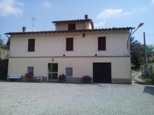 a white house with a bench in front of it at la buca delL'IStrice in Monteriggioni