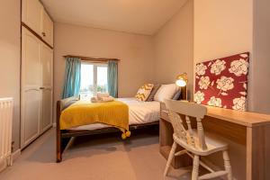 a small bedroom with a bed and a desk at Charming Cottage in the Heart of Newport - Pass the Keys in Newport