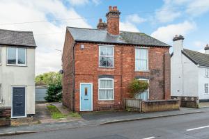 a brick house with a blue door on a street at Charming Cottage in the Heart of Newport - Pass the Keys in Newport