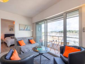a living room with a couch and a table with orange pillows at Charmant T2 avec vue port, idéal pour 4 pers. à La Trinité-sur-Mer - FR-1-477-78 in La Trinité-sur-Mer