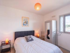 a bedroom with a bed and two lamps and a television at Charmant T2 avec vue port, idéal pour 4 pers. à La Trinité-sur-Mer - FR-1-477-78 in La Trinité-sur-Mer