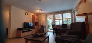 een woonkamer met een bank, een televisie en een tafel bij Schau ins Land 2 in Elbingerode